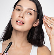 Close-up of a model 's face applying eyelash conditioner